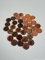 All 36 Canadian pennies laid out on white surface