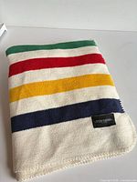 Folded blanket showing multicolor stripes and woven label