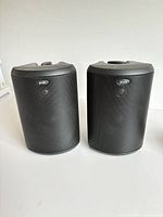 Front view of both Polk Audio Atrium 45 speakers showing black metal grilles