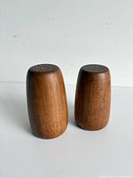 Front view of both walnut shakers showing grain and size comparison