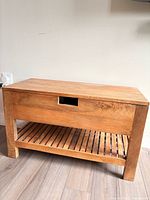 closed view of solid wood bench, showing front and slatted shelf