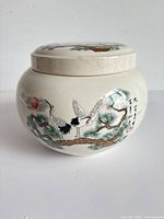 Front view of ceramic jar showing crane and pine design and calligraphy