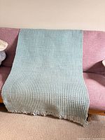 Full rug draped over sofa showing overall size, colour and weave