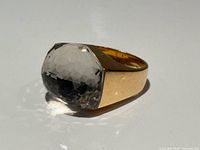Angled view of ring showing faceted quartz and gold band