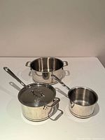 All three cookware pieces and lid arranged on table