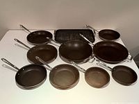 Top-down view of all ten cookware items arranged on table