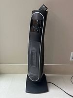 Full view of Bionaire ceramic tower heater standing on base with power cord visible