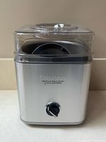 Front view of Cuisinart ice cream maker showing stainless body and control dial