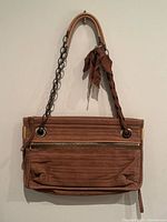 Front view showing quilted leather, chain handle, front zip pocket