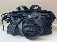 Full front view of black ruched Lululemon duffel bag