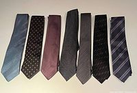 Seven ties laid out front side visible showing colour and pattern