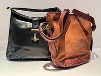 Front view of both handbags side by side showing materials and hardware