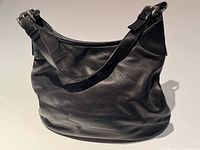 Front view of black leather Prada shoulder bag showing silver-tone hardware and strap