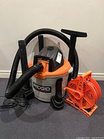 Ridgid wet/dry vacuum with hose, wands, floor nozzle and orange cord reel
