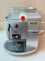 Front and top view of Saeco espresso machine with bottle on cup warmer