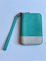 Front view of Tiffany blue and white leather zipper wristlet wallet with strap attached