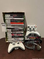 Full lot showing stacked games, two controllers and headset
