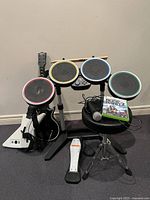 Full set showing drums, guitars, foot pedal, sticks, game, mic