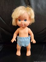 Front view of blonde baby doll in blue diaper