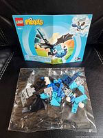 Instruction booklet front cover and sealed parts bag displayed on black leather surface