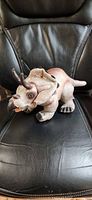 Front three-quarter view of plush triceratops on chair