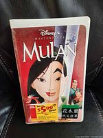 Front view of sealed Disney Mulan VHS showing cover art, shrink-wrap, coupon sticker
