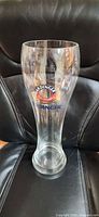Full view of tall Erdinger 3 L beer glass seated on chair