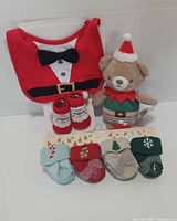 Front view of all items: bib, booties, plush bear, sock pack