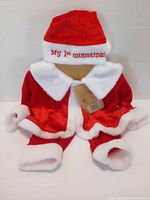 Front view of baby Santa outfit showing coat, pants, hat and tag