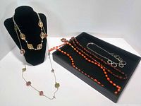 All five necklaces displayed on bust and tray