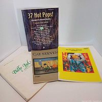 Front covers of all four sheet music books displayed