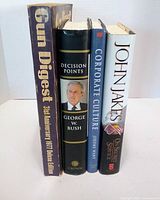 Spine view of four hardcover books standing upright