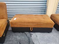 Full view of ottoman closed showing tufted top and base