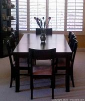Dining table with six chairs shown indoors