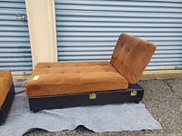 Chaise lounge side view with backrest raised showing tufted camel microfiber cushion on black base