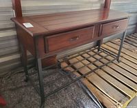 Front angle view of console table showing wood top, two drawers, metal frame and lower shelf