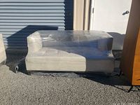 Front view of wrapped light beige loveseat