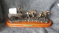 Full view of bronze-tone horse and wagon sculpture on wooden base