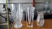 Three crystal vases side by side on table