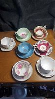 All seven teacup and saucer sets displayed