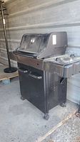 Full view of Weber Spirit grill angled front left highlighting cabinet and side shelf