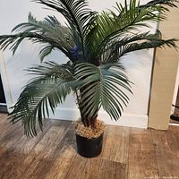 Full view of artificial palm tree showing fronds and pot