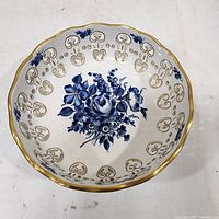 Top view showing blue floral painting and gilded scalloped rim