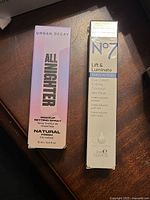 Urban Decay All Nighter Setting Spray box and No7 Lift & Luminate Eye Cream box side by side
