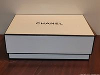 Front view of white Chanel box with logo