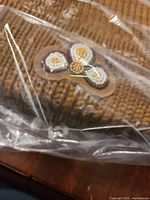 Beaded floral patch detail on knit toque through packaging