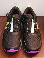 Top view of both shoes showing black mesh, teal stripe, yellow logos