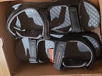 Top view of both sandals inside the box showing straps and footbeds