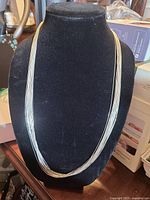 Front view of entire sterling silver multi-strand necklace on display bust