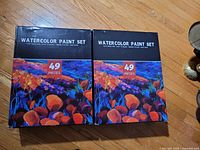 Front view of both unopened watercolor paint set boxes